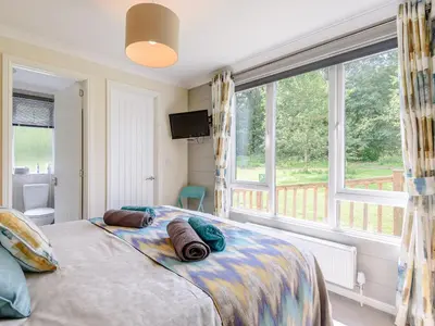 a bedroom with a bed and a large window at Bryn Teg - Cottage in Maesmynis