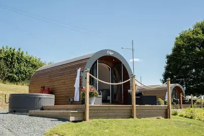 a round wooden trailer with a porch and a building at Celyn in Welshpool