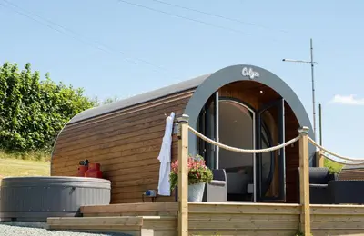 a tiny house with a circular door and a porch at Celyn in Welshpool
