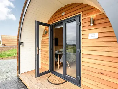an open door of a tiny house with a patio at Cae Bitfel - Cottage in Llanwddyn