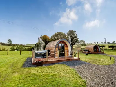 a luxury yurt in a grassy field with a house at Chestnut Uk36261 in Llanfair Caereinion