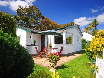 a small white house with a table and chairs at Fron - Cottage in Mynfford