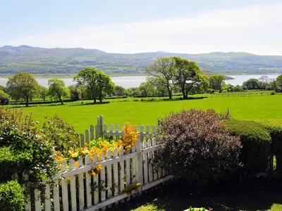 a white picket fence in front of a field at Fron - Cottage in Mynfford