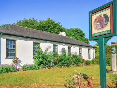 a white building with a sign in front of it at Fron - Cottage in Mynfford