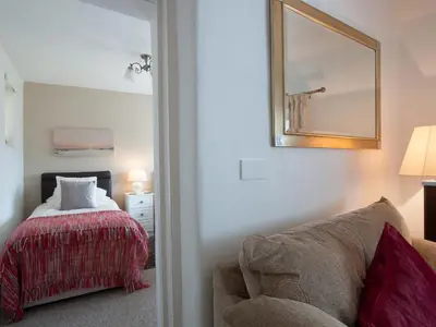 a bedroom with a bed and a mirror and a chair at Fron - Cottage in Mynfford