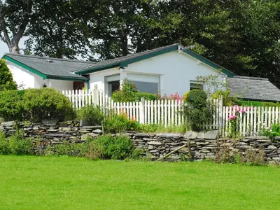 a white house with a fence and a yard at Fron - Cottage in Mynfford