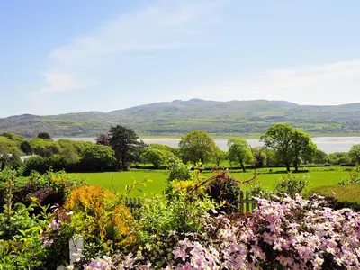 a garden with a view of the water and mountains at Fron - Cottage in Mynfford