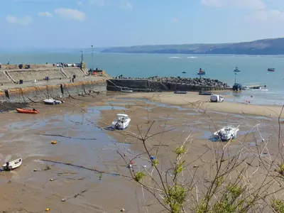 a beach with boats on the sand and the ocean at Y Ty Glas - Cottage in New Quay