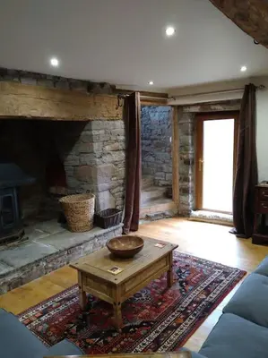 a living room with a stone fireplace and a coffee table at Wern Ddu, Defynnog - Brecon Beacons in Brecon