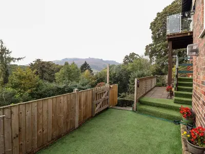 a backyard with a fence and green lawn at Westoe Hideaway in Llangollen