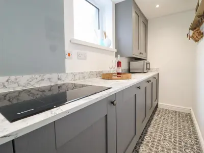 a kitchen with gray cabinets and a counter top at 3 Ivy Court in Dolgellau