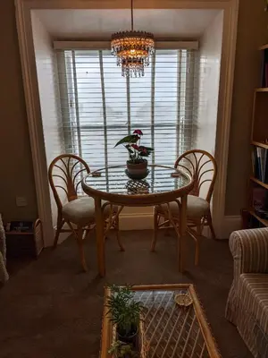 a dining room table with chairs and a chandelier at Pier View Sea View Apartment Aberystwyth Promenade in Aberystwyth