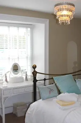 a bedroom with a bed and a window and a chandelier at Pier View Sea View Apartment Aberystwyth Promenade in Aberystwyth
