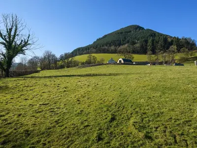 a green field with a house on top of a hill at Creyr Glas Pod -Uk41796 in Hirnant