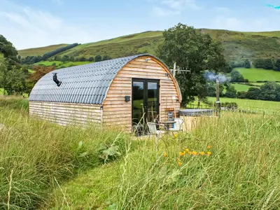 a small wooden shed in a field of grass at Creyr Glas Pod -Uk41796 in Hirnant
