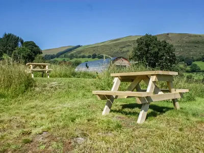 a picnic table in a field with a hill in the background at Creyr Glas Pod -Uk41796 in Hirnant
