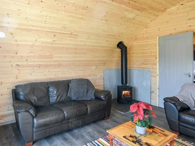 a living room with a leather couch and a stove at Creyr Glas Pod -Uk41796 in Hirnant