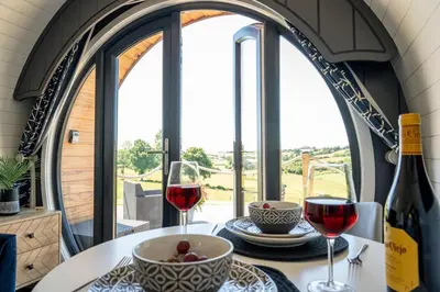 a table with two glasses of red wine on a table with windows at Bedwen in Welshpool