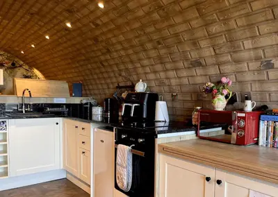a kitchen with a counter top with a stove top oven at Owl Hollow in Llansantffraid-ym-Mechain