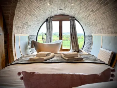 a bedroom with a large bed with a window at Rabbits View in Rhayader
