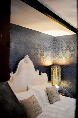 a bedroom with a white bed with a blue wall at Plas Dolguog in Machynlleth