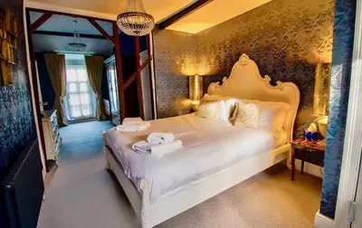 a bedroom with a white bed with towels on it at Plas Dolguog in Machynlleth