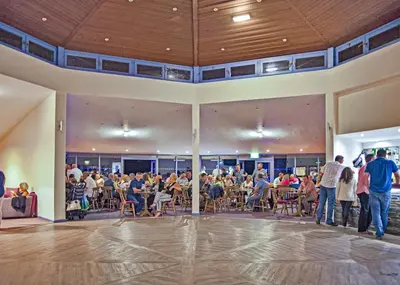 a group of people standing in a large room with a crowd at Sunbeach Holiday Park in Llwyngwril