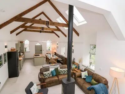 a living room with couches and a stove at Ysgoldy Brynwyre in Llanrhystyd