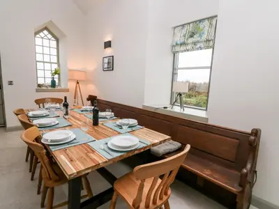 a dining room with a wooden table and chairs at Ysgoldy Brynwyre in Llanrhystyd