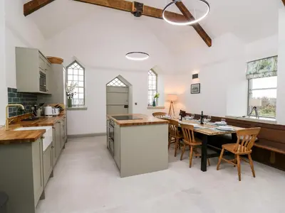 a kitchen with a table and chairs and a ceiling at Ysgoldy Brynwyre in Llanrhystyd