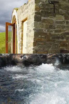 a stone building with a pool of water at Hare's View in Rhayader