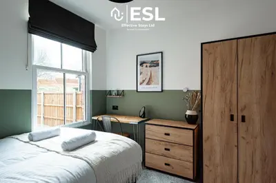 a bedroom with a bed and a dresser and a window at 5 Bedroom Victorian Town House - Perfect for Contractors and Family Groups in Shrewsbury