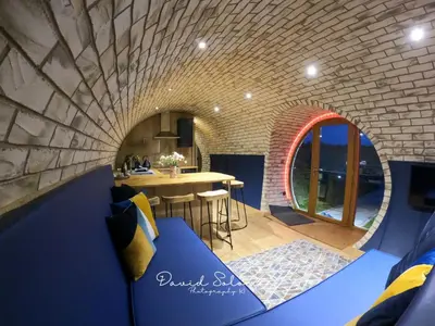 a room with a brick wall and a blue couch at Badgers View in Rhayader