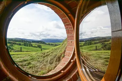 a circular window looking out at a green field at Badgers View in Rhayader
