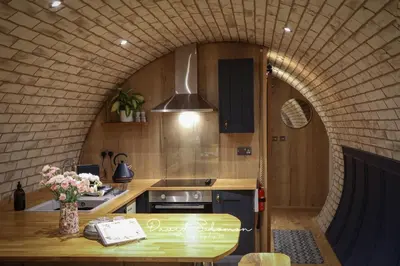 a kitchen with an arched ceiling and a table with flowers at Badgers View in Rhayader