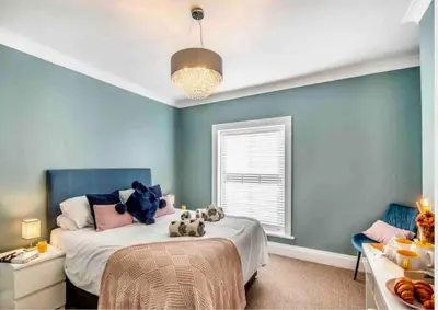 a bedroom with a bed with stuffed animals on it at Jack's House in Tywyn