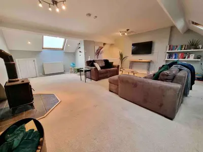 a large living room with a couch and a tv at Jack's House in Tywyn