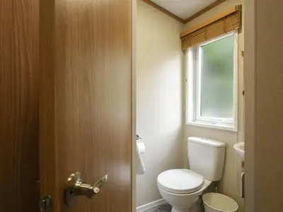a bathroom with a toilet and a window at Marlow Lodge in Hyssington