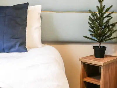 a christmas tree on a night stand next to a bed at Marlow Lodge in Hyssington