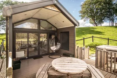 a tiny house with a table and a chair on a deck at Hillside Lodge in Nantmel