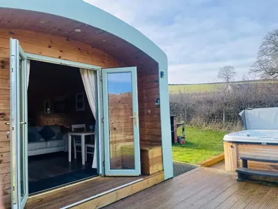 a large sliding glass door on a deck with a table at Hwyl in Abbey-Cwmhir