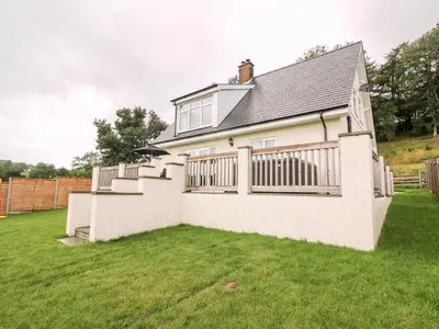 a white house with a fence and a yard at Lower Pentre in Llanddewi Ystradenny