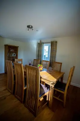 a dining room with a wooden table and chairs at Lower Pentre in Llanddewi Ystradenny