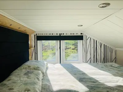 a bedroom with a bed in front of a window at Meadow Retreat in Rhayader