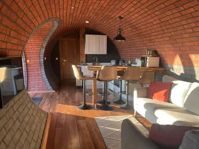 a living room with a couch and a brick wall at Otters View in Rhayader