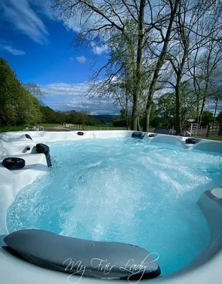 a swimming pool with blue water in a park at Panteg in Llanrhaeadr-ym-Mochnant