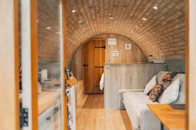 a living room with a couch and an archway in a train at Panteg in Llanrhaeadr-ym-Mochnant