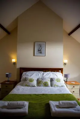 a bedroom with a bed with two towels on it at Pentre Fawr in Llanddewi Ystradenny