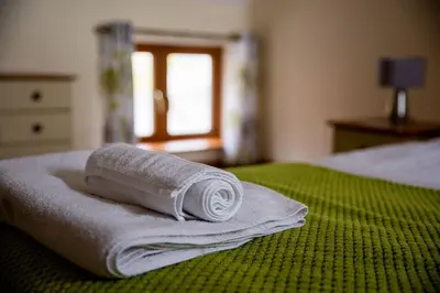 a pile of towels sitting on top of a bed at Pentre Fawr in Llanddewi Ystradenny