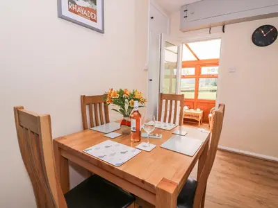 a dining room table with chairs and a wooden tableablish at Tegfan Bungalow in Pant-y-dwr